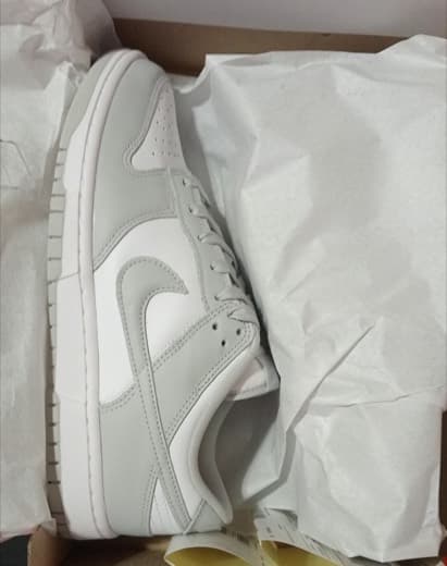 Grey and white Nike Dunk Low in tissue paper